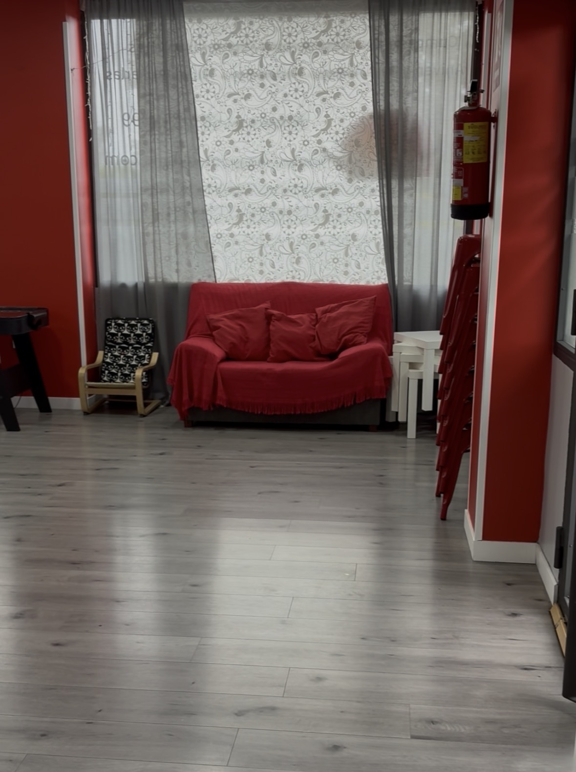 Zona de descanso con sofá rojo en sala de fiestas Moratalaz Madrid